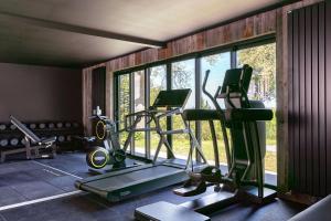 a room with a gym with tread machines and windows at La Chaumière in Honfleur