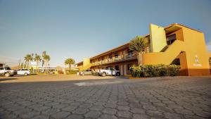 a building with a large letter k next to a parking lot at HOTEL & SUITES MARROD in Chihuahua