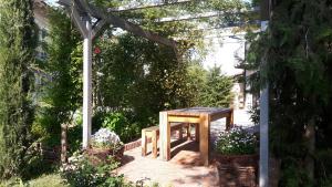 uma pérgola de madeira com uma mesa de madeira num jardim em Casa Nalin em La Morra