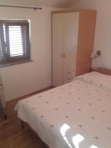 Schlafzimmer mit einem Bett und einem Fenster in der Unterkunft Apartman-NENA- in Veli Iž