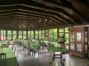 a dining room with green tables and chairs at Pousada Villa Real in Tiradentes