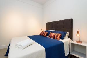 een slaapkamer met een groot bed met blauwe lakens en kussens bij Qto&Sala a 220m da Praia de Copacabana | RP 95/202 in Rio de Janeiro
