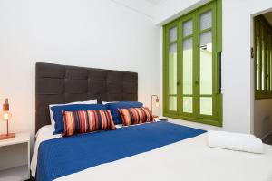 1 dormitorio con 1 cama grande con almohadas azules y rojas en Qto&Sala a 220m da Praia de Copacabana | RP 95/202, en Río de Janeiro