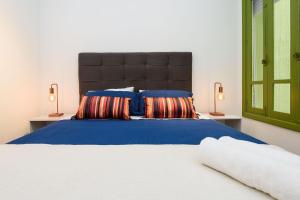 een slaapkamer met een groot bed met blauwe lakens en kussens bij Qto&Sala a 220m da Praia de Copacabana | RP 95/202 in Rio de Janeiro