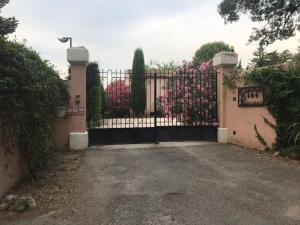 a gate to a house with pink flowers on it at B&B Les Muscades in Saint-Étienne-du-Grès