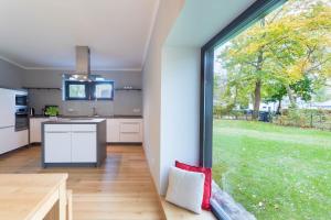 eine offene Küche mit einem großen Fenster in einem Haus in der Unterkunft Quartier Scharmützelsee in Bad Saarow