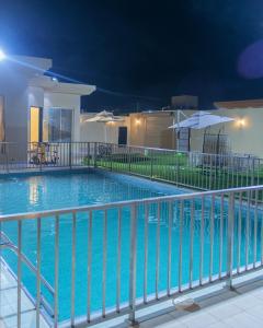 a swimming pool at night with a fence at شاليهات فيفيان بارك Vivian Park Chalets in Al Kharj