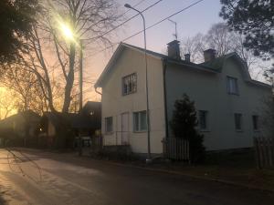uma casa branca com uma luz de rua ao lado em Puutaloasunto 1 km Turun Aurajoelta föriltä em Turku