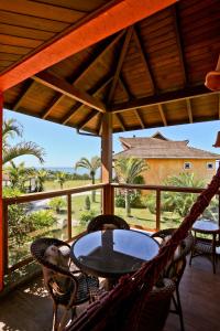 a porch with a hammock and a table and chairs at Estaleiro Guest House in Balneário Camboriú