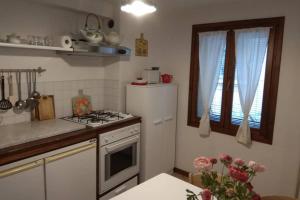 a kitchen with a stove and a white refrigerator at Casa DA.MA. CORNARO centro storico in Asolo