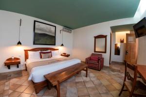 a bedroom with a large bed and a television at Casa De Sierra Azul in Oaxaca City