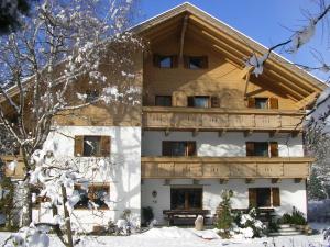 a large wooden building with a balcony in the snow at Burgblick in San Lorenzo di Sebato