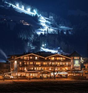 ein großes Gebäude in der Nacht mit einem Berg in der Unterkunft Hotel Tipotsch in Stumm