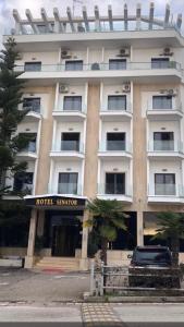 ein Gebäude mit einem Hotelstandard davor in der Unterkunft Hotel Senator in Sarandë