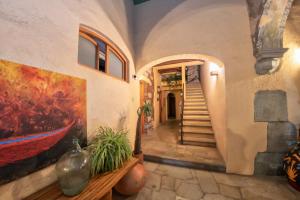 a hallway of a house with a painting and stairs at Casa De Sierra Azul in Oaxaca City
