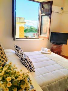 een slaapkamer met een bed, een raam en een televisie bij Summer Dream LA CASA SUL MARE in Trappeto