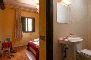 a bathroom with a sink and a bedroom with a bed at Hotel Soleil Imlil in Imlil