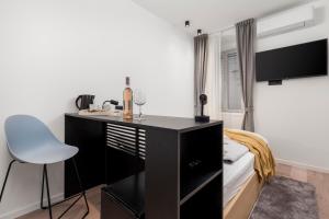 Schlafzimmer mit einem Schreibtisch und einem Bett mit einem Stuhl in der Unterkunft Deluxe Apartments & Rooms "In the Center" in Rijeka