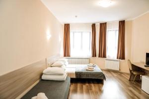 a hotel room with two beds and a desk at Villa Kmeller in Lviv
