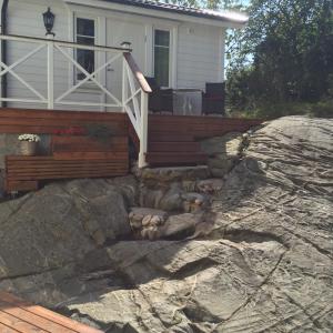 a house on a large rock in front of a house at Peaceful Cottage in Gothenburg