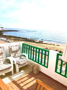 balcón con 2 sillas y vistas a la playa en Luxury Suite Sea Front en Playa Honda