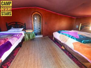 two beds in a room with red walls at Camp Desert Stars in Mhamid