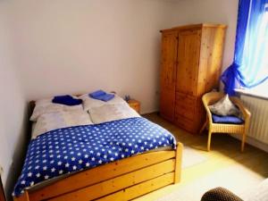 a bedroom with a bed and a cabinet and a chair at Ferienwohnung Hermann in Spangenberg