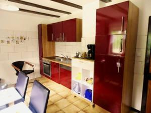 a kitchen with red cabinets and a table and chairs at Ferienwohnung Hermann in Spangenberg