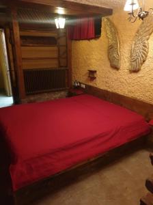 a red bed in a room with wings on the wall at Apartma Miša in Prevalje