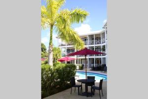 Blick auf ein Resort mit einem Tisch, Stühlen und einem Pool in der Unterkunft Sea Glass Villa - Spacious 2 Bedroom, 2 Bathroom in Saint James