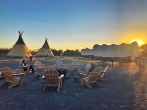a group of chairs and tents with the sun setting at Orr Family Farm & RR, LLC in Oklahoma City