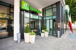 Holiday Inn Turin Corso Francia, an IHG Hotel في تورينو: مبنى به نباتات خزف خارجه
