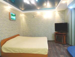 a bedroom with a bed and a flat screen tv at Apart in Kropyvnytskyi