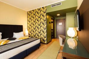 a bedroom with a bed and a flat screen tv at Holiday Inn Turin Corso Francia by IHG in Turin +35 photos