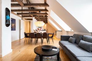 a living room with a couch and a table at Town Hall Penthouse by Daniel&Jacob's in Copenhagen