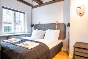 a bedroom with a bed with two towels on it at Town Hall Penthouse by Daniel&Jacob's in Copenhagen