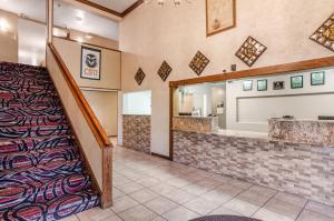 a living room with a large mirror and a stairway at Americas Best Value Inn & Suites Ft Collins E at I-25 in Fort Collins