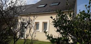 a white house with a black roof at L'Escale au Coteau in Sucé