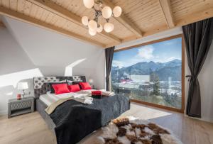 a bedroom with a bed and a large window at Osada Gubałówka na Polanie Pająkówka & SPA in Kościelisko