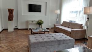 ein Wohnzimmer mit einem Sofa und einem Tisch in der Unterkunft Hotel Viña de Italia in Cordoba