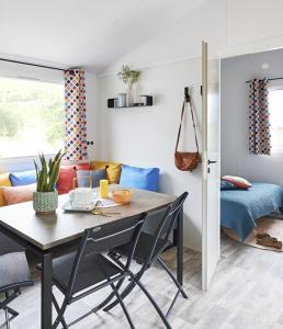 ein Esszimmer mit einem Tisch und einem Sofa in der Unterkunft Camping de la Croix d'Arles in Bourg
