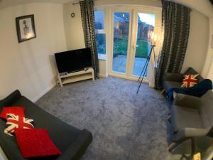a living room with a couch and a television at Harpers brook house, Netflix TVs and fast WIFI in Corby