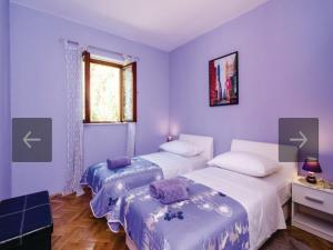 2 łóżka w pokoju z fioletowymi ścianami w obiekcie Beach Heaven Home w mieście Slano