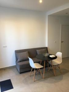 een woonkamer met een bank en een tafel en stoelen bij apartamento cristina in El Rompido