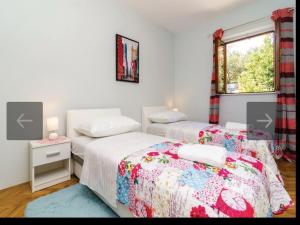 2 łóżka pojedyncze w pokoju z oknem w obiekcie Beach Heaven Home w mieście Slano