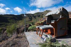 Luxury villa in Nature with Swimming pool Tenerife, Santiago del Teide, with sea and mountain views في El Retamar: جلسه مجموعه كراسي فوق جبل