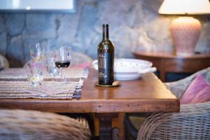 Una botella de vino sentada en una mesa de madera con copas en Luxury villa in Nature with Swimming pool Luxus-Finca in der Natur mit pool, Finca de lujo en la naturaleza con piscina en El Retamar