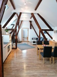 sala de estar con techos de madera, mesa y sillas en Ferien im Elsass, en Artolsheim