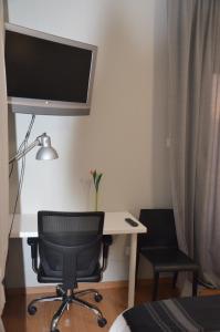 a bedroom with a desk and a chair and a computer at Strovolos Value Suites in Strovolos