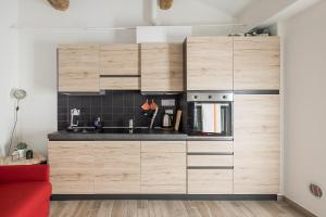 una cucina con armadi in legno e un divano rosso di AP Appartamenti Urbik a Bologna